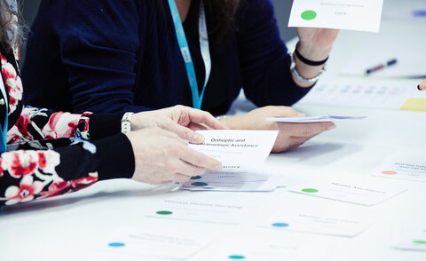 Hände mit Karten, auf denen verschiedene Studiengänge zu lesen sind