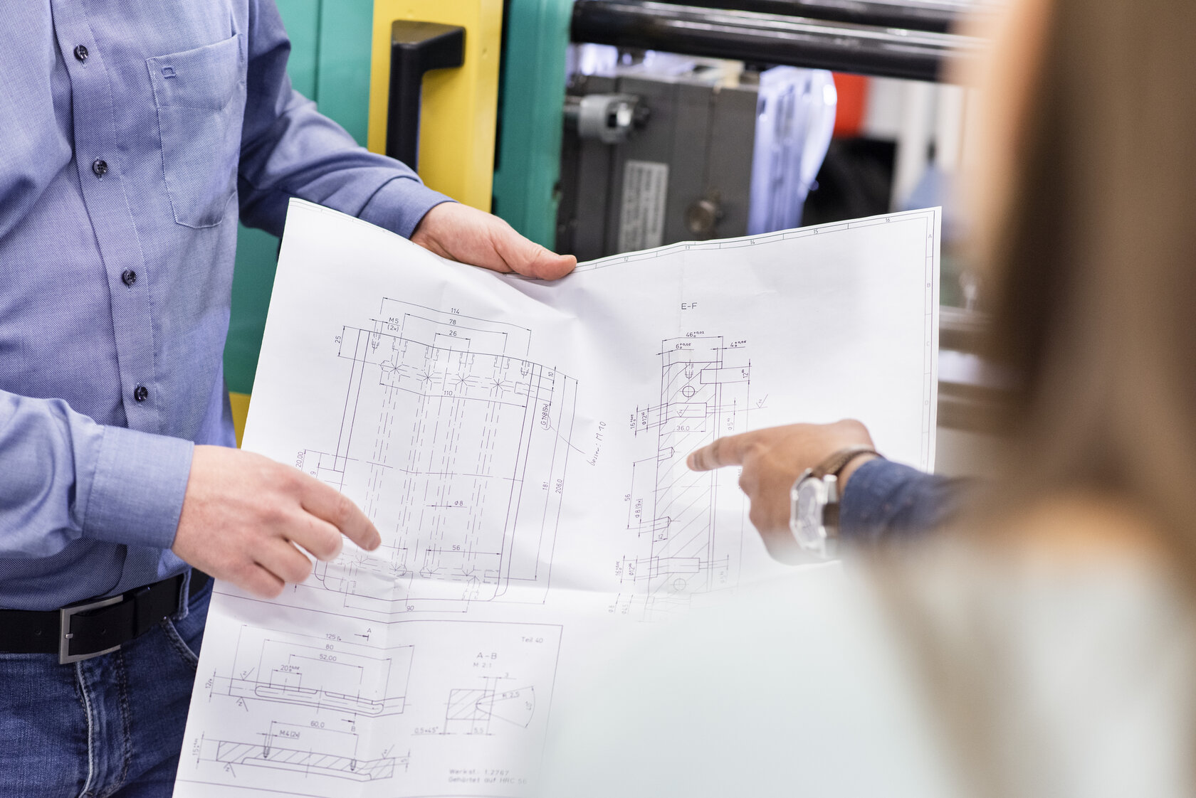 close-up of hands holding paper with machine draft