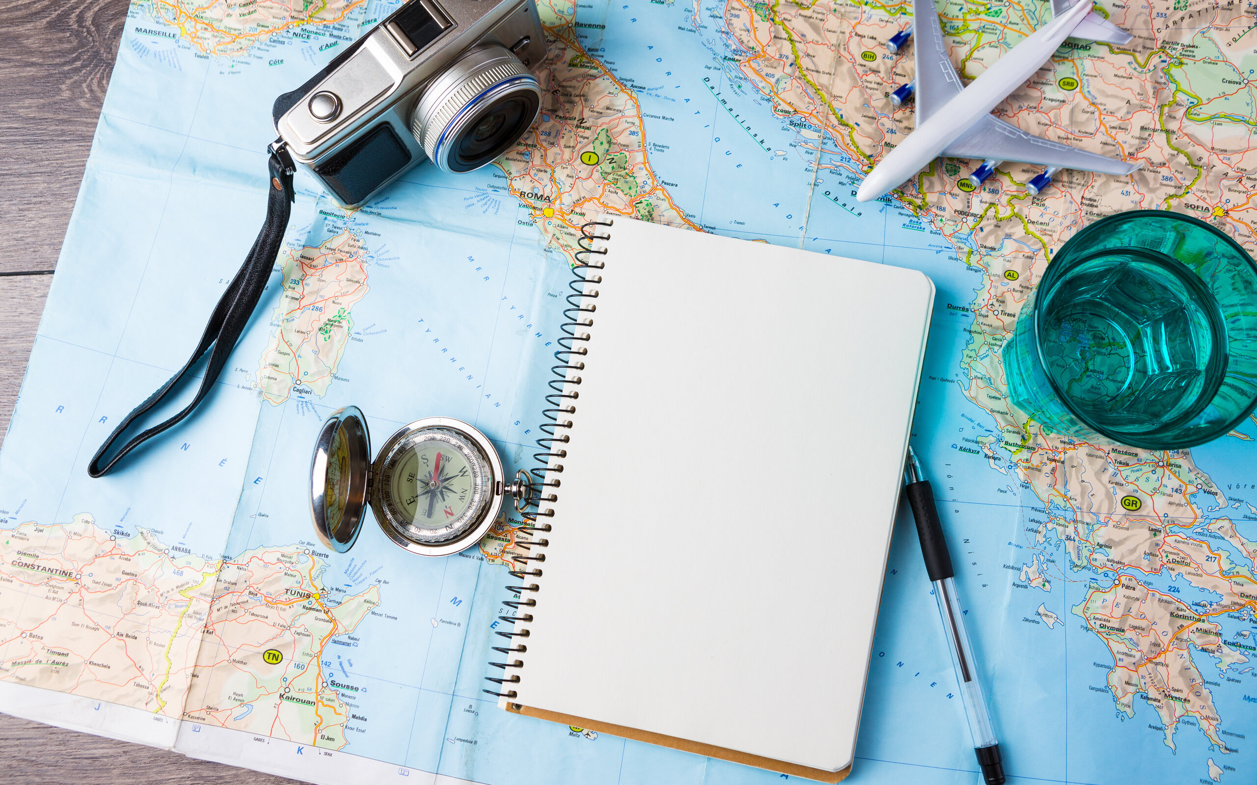 verschiedene Reiseutensilien auf einer Landkarte verschiedene Reiseutensilien auf einer Landkarte