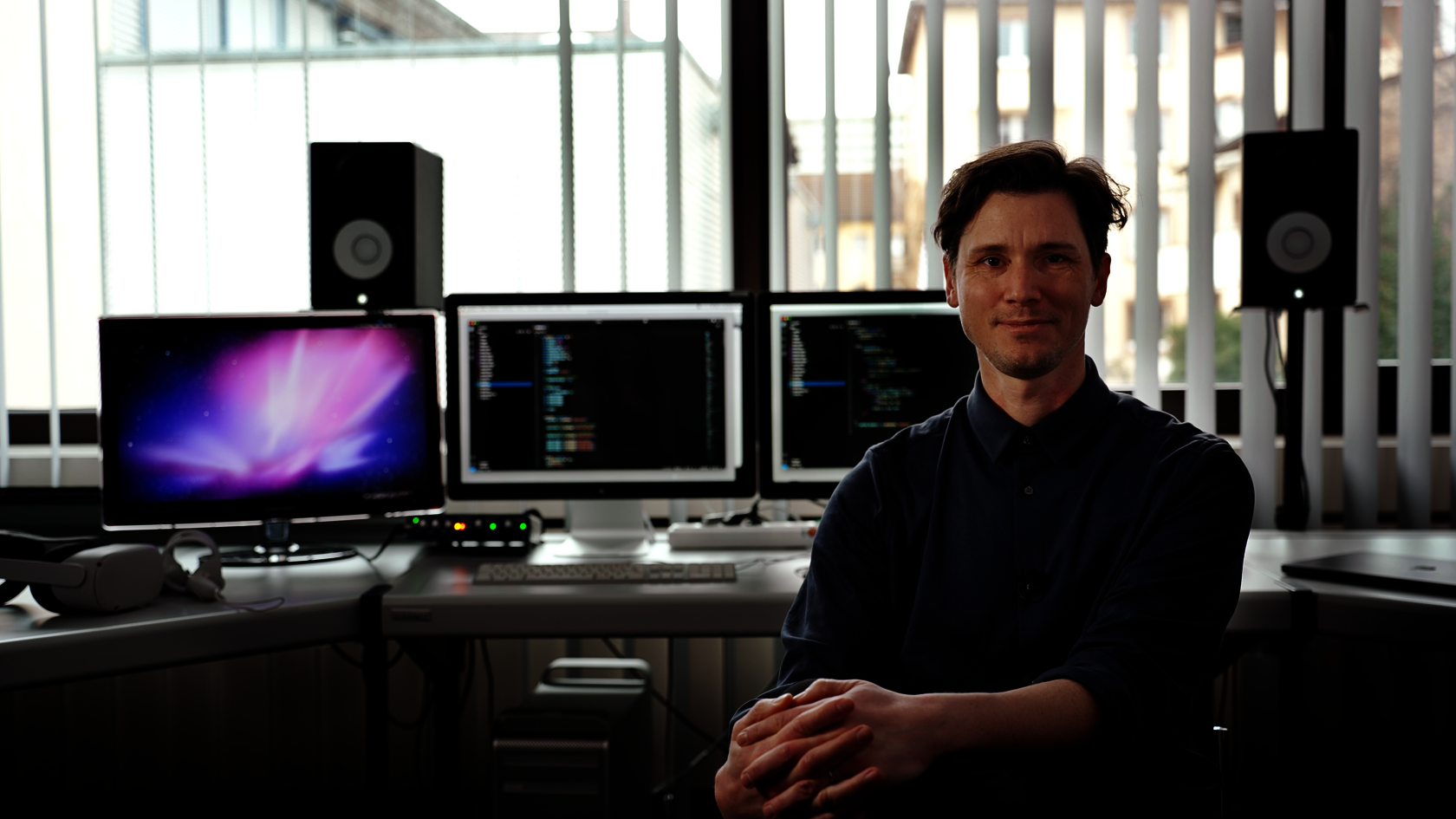 Prof. Moritz Schell vor Bildschirmen mit Code