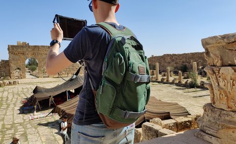student at historic site, looking at a tablet