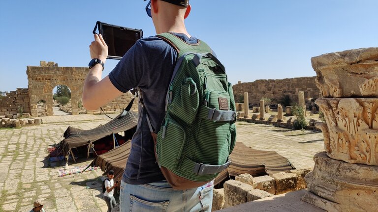 student at historic site, looking at a tablet