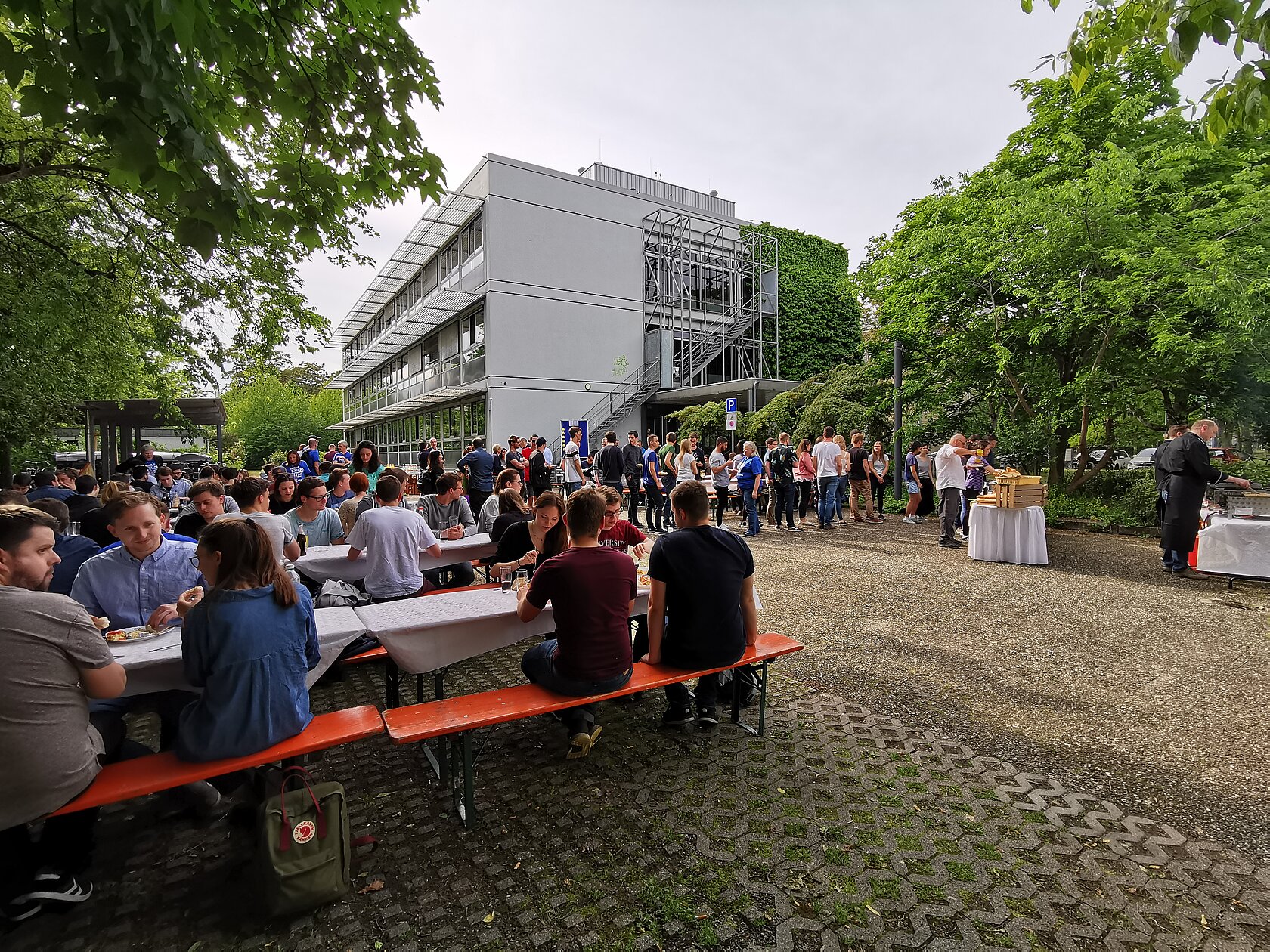 a summer party of students sitting at beer tables on campus