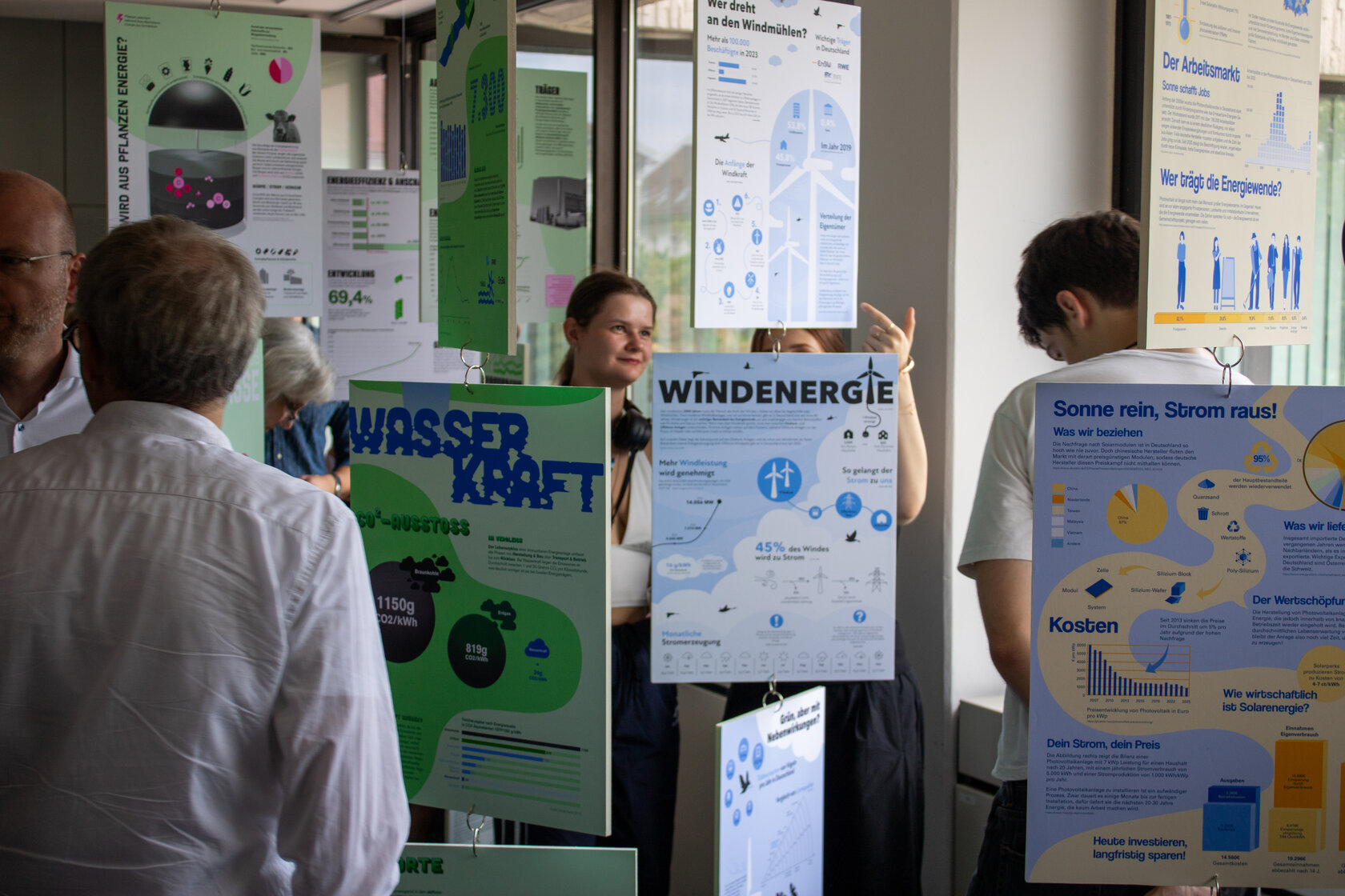 Von der Decke hängende Tafeln, die Inforgrafiken zu verschiedene Energiequellen zeigen