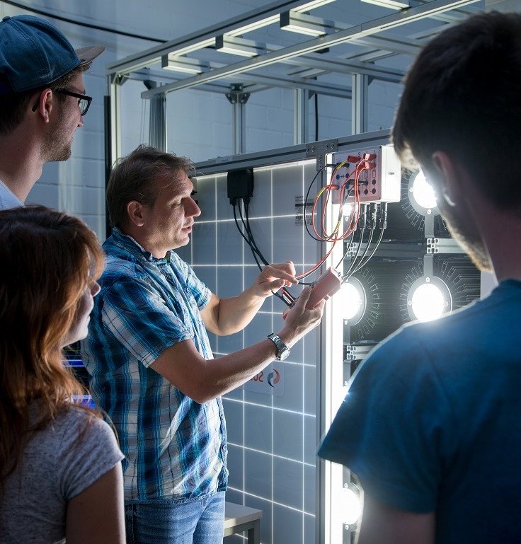 Professor and students are working on a photovoltaic system