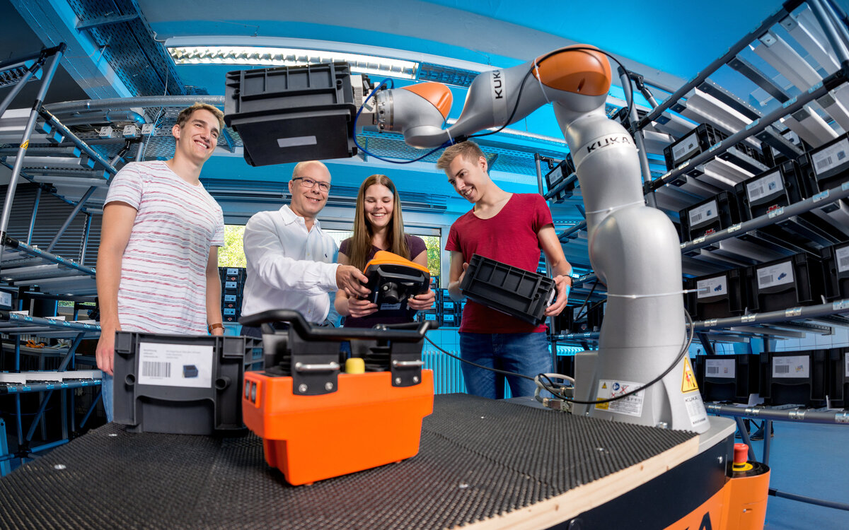 Forschungsgruppe Robotik und Intelligente Systeme (iRAS) am IAF: Studierende um Prof. Dr.-Ing. Christian Wurll an einem KUKA Industrieroboter 