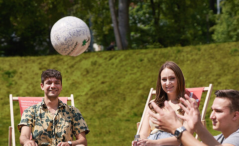 Das Bild zeigt Studierende beim Ballspiel auf dem Campus