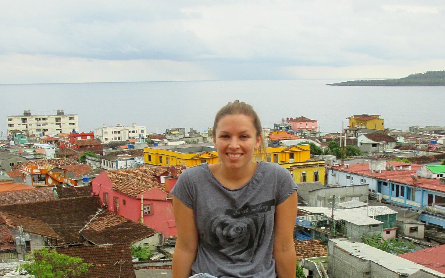 Doktorandin Sandra Lichtblau vor einem kubanischen Dorf mit Ausblick auf das Meer.