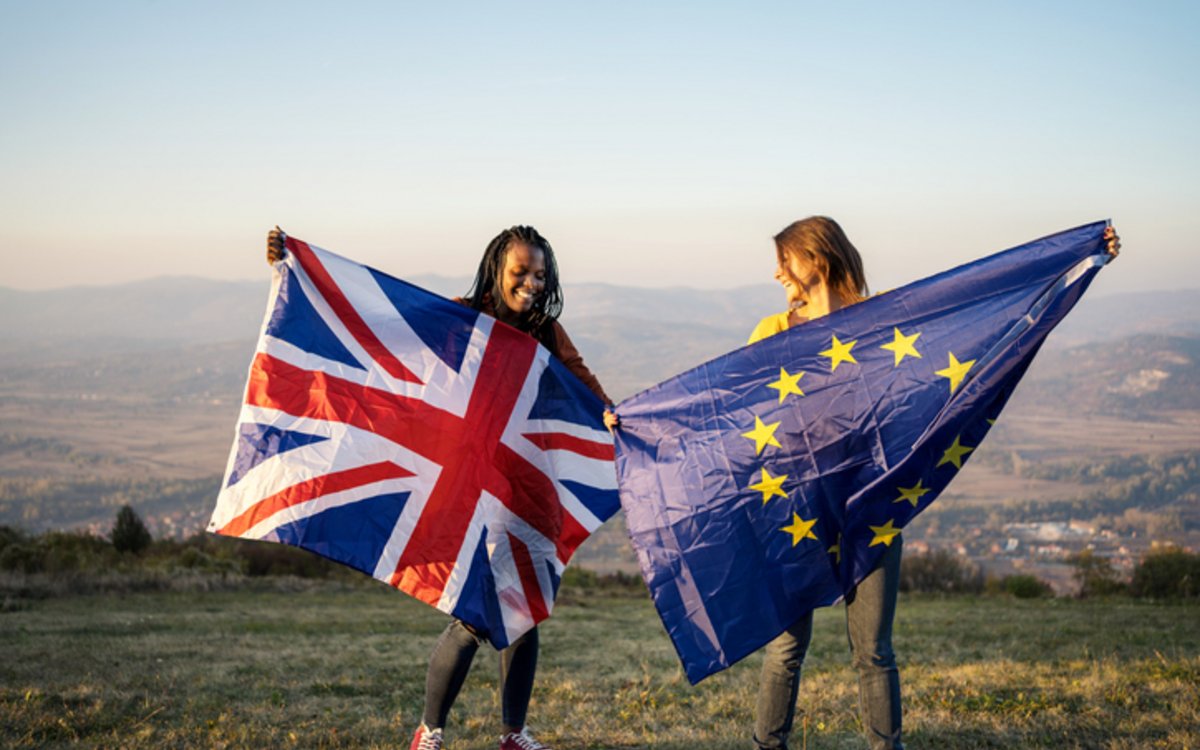Zwei Frauen mit je einer EU-Fahne und einer UK-Fahne in der Hand