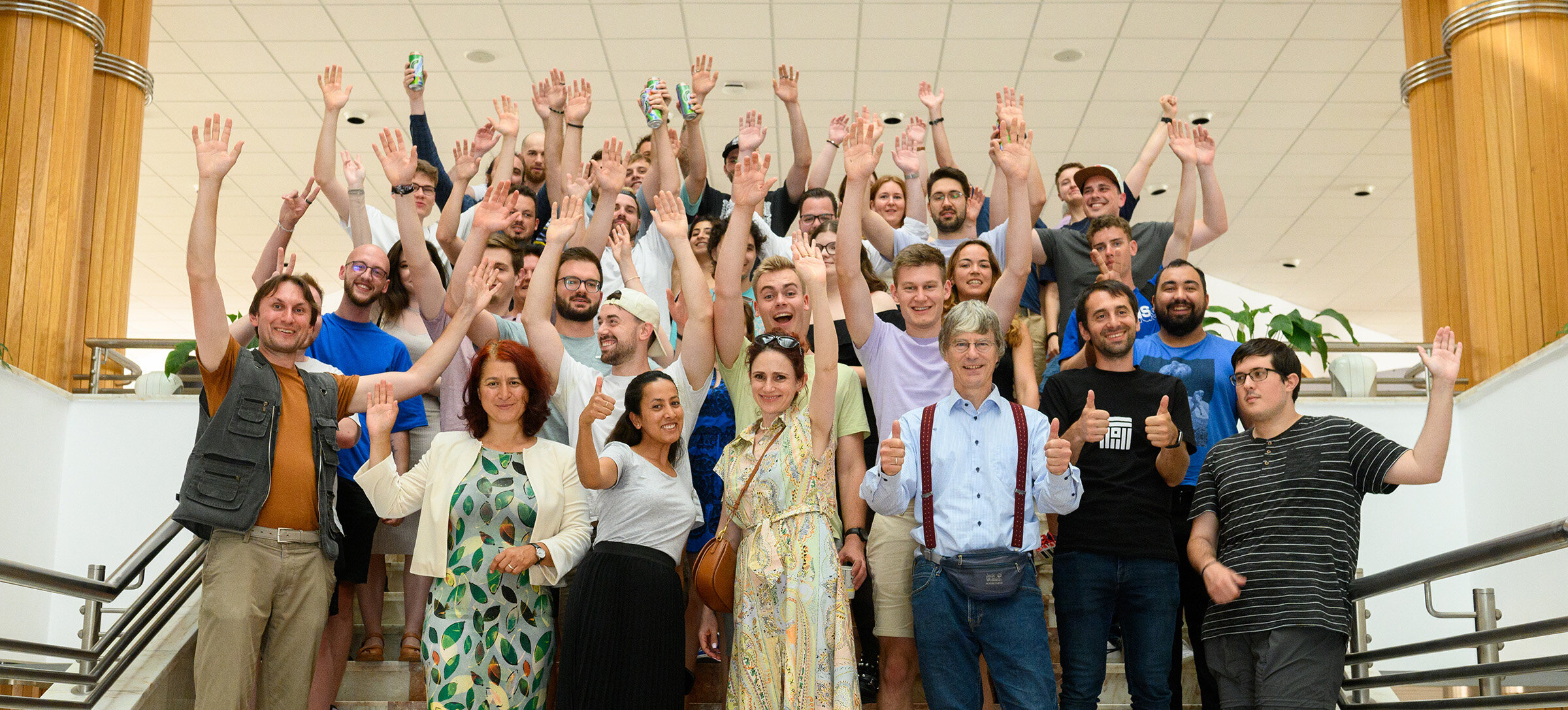 summer school participants standing on a stairs and waving