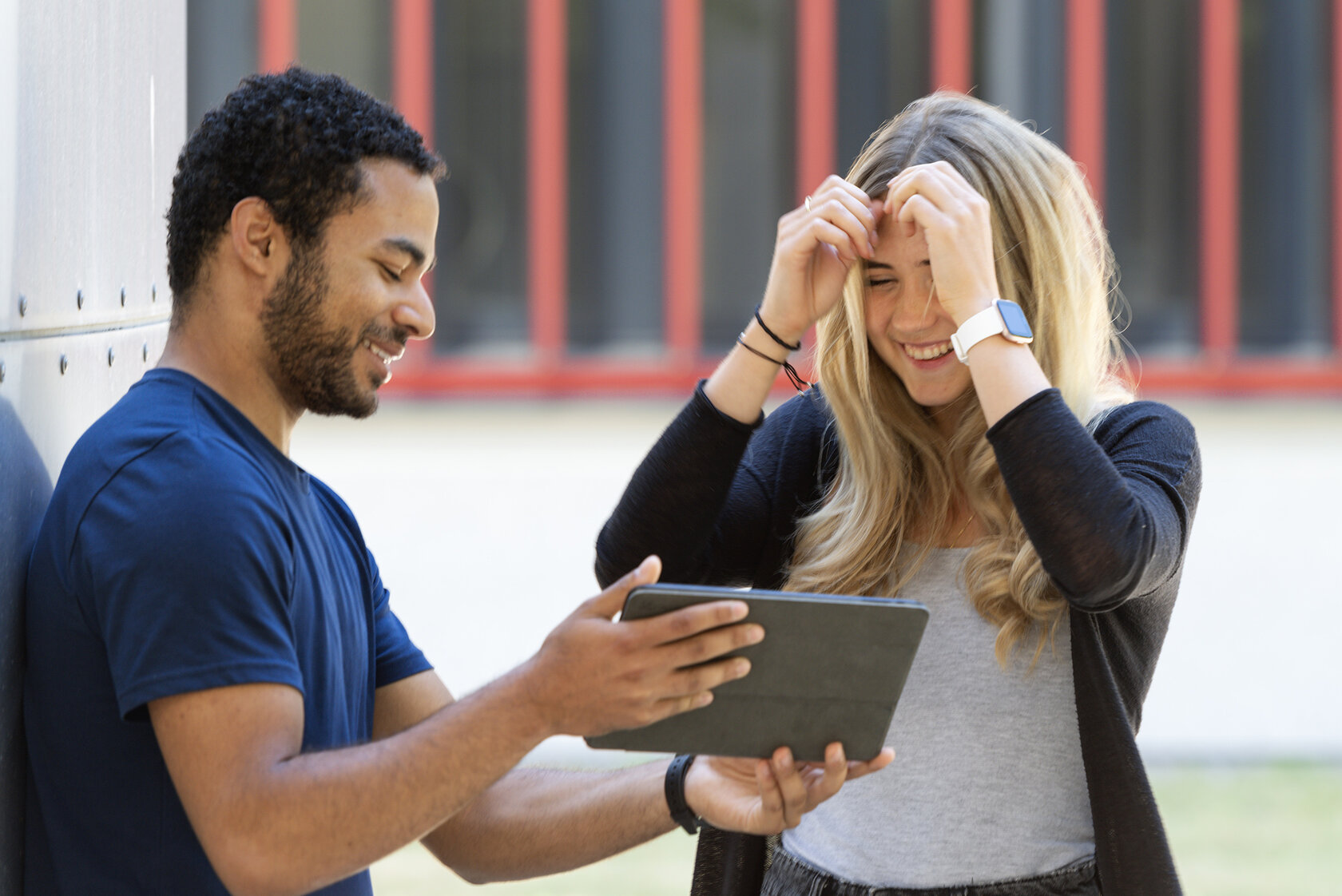 student showing some information on a tablet to a fellow student student showing some information on a tablet to a fellow student