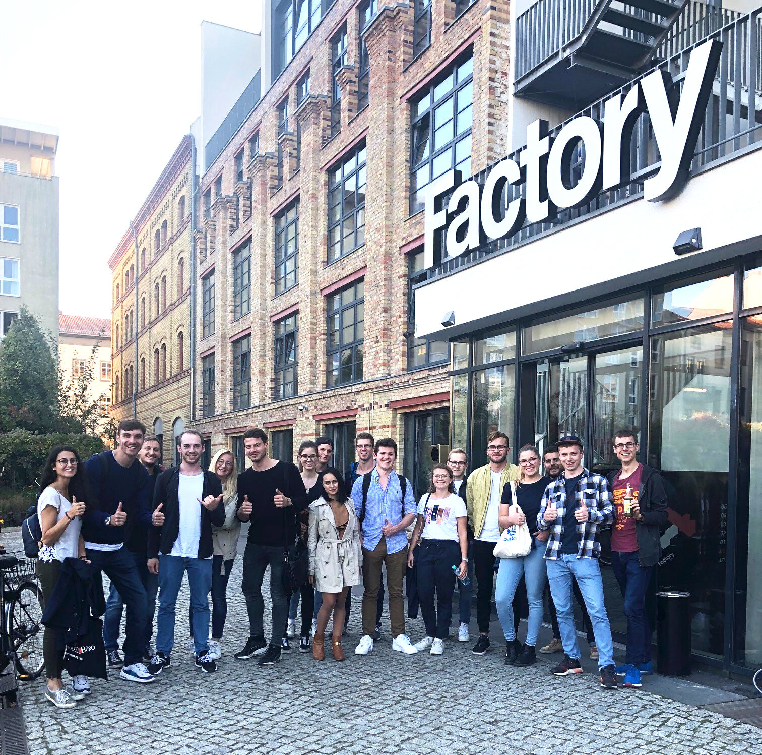 group of students standing in front of the "Factory" building