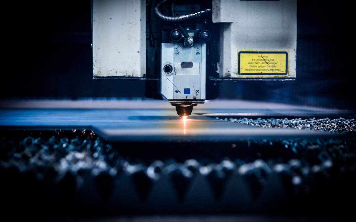 Close-up of machine tool working a flat sheet of metal