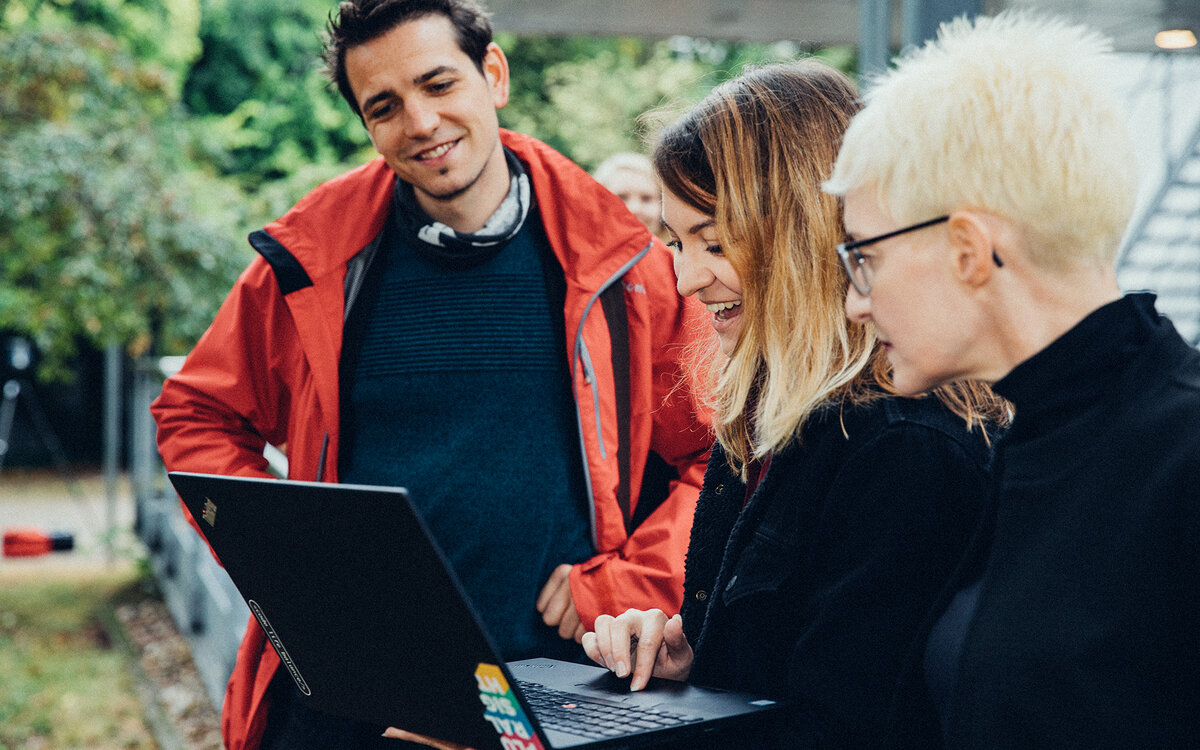 group of students looking at a laptop