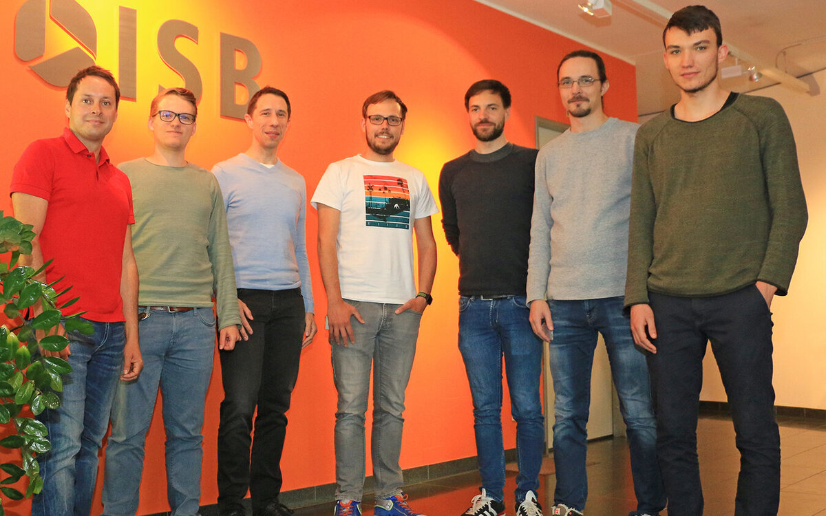 ISB AG employees standing in the lobby in front of company logo
