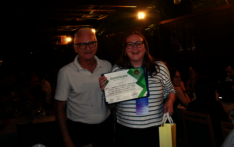 Promotionsstudentin Fiona Schmidbauer (IIIX) steht rechts neben dem Konferenzvorsitzenden Prof. Mario Barajas Frutos bei der Preisverleihung des Best Student Paper Award auf der ICETC 2025 und h&auml;lt das Zertifikat f&uuml;r den Award in der Hand.